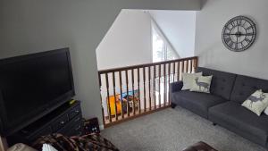 a living room with a couch and a flat screen tv at Secluded Chalet in Harrison