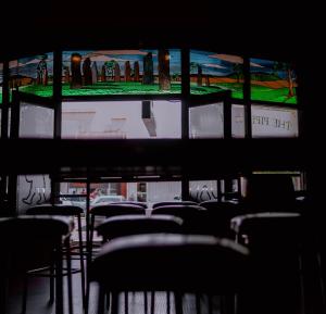 a group of chairs in a room with windows at The Great Central Hotel in Glen Innes