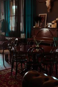 a dining room with a table and chairs and a piano at The Great Central Hotel in Glen Innes