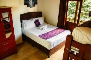 a bedroom with a bed with a stuffed animal on it at Apartahotel Balcones de Nariño 2 in Villa de Leyva