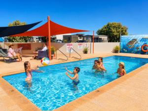 a group of children playing in a swimming pool at Sunset Beach Holiday Park in Geraldton