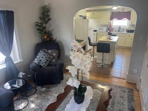 a living room with a chair and a table with flowers at Fall River Stay Stylish 2BR Urban Haven Suite in Fall River