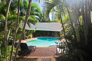 a swimming pool in a yard with palm trees at Ocean Sands Resort in Gold Coast