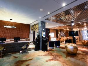 a lobby with a large room with a table and chairs at CHECK inn HIVE in Luodong
