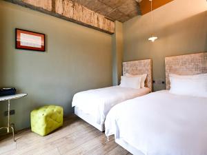 two beds sitting next to each other in a room at CHECK inn HIVE in Luodong