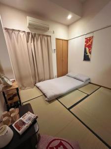 a small room with a bed and a window at 一心館sakura401 in Wada