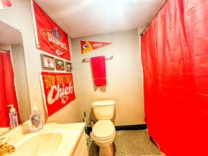 a bathroom with a red shower curtain and a toilet at Triple Crown KC in Kansas City +18 photos