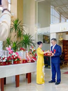 a man and a woman holding a plate of food at Le Centre Pleiku Hotel in Pleiku