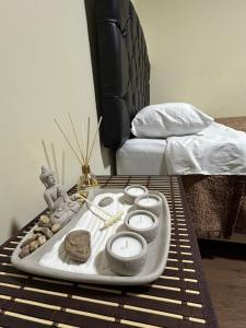 a tray with candles on a table next to a bed at Flamante Atardecer in Paracas