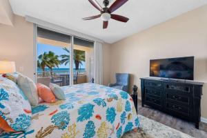 a bedroom with a bed and a flat screen tv at 2BR Beach Condo Shared Pool Tennis Courts in Gulf Shores