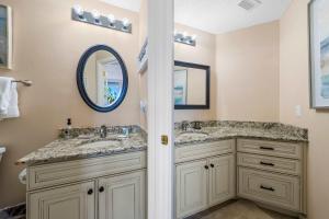 a bathroom with two sinks and a mirror at 2BR Beach Condo Shared Pool Tennis Courts in Gulf Shores +19 photos