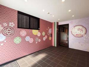 a room with pink walls with hello kitty stickers on the wall at RESI STAY Yasaka in Kyoto +23 photos