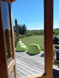 a porch with two green bean bags on a deck at Freefall Cottage in Haumoana