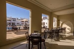 a restaurant with tables and chairs and a large window at Mazar Resort & Spa in Sharm El Sheikh