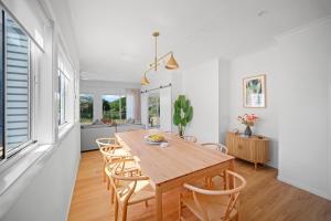 a dining room with a wooden table and chairs at The Lookout in Diamond Beach
