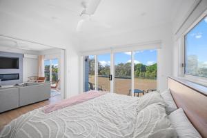 a bedroom with a large bed and a large window at The Lookout in Diamond Beach