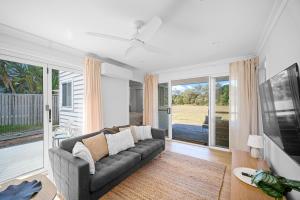 a living room with a couch and a tv at The Lookout in Diamond Beach