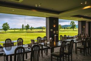 a restaurant with tables and chairs and a large window at Hokkaido Zen Cabin in Bibai