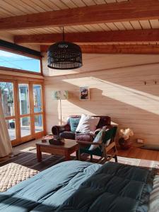 a bedroom with a bed and a couch and a table at Freefall Cottage in Haumoana