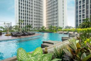 a swimming pool in the middle of two tall buildings at Louis Kienne Reserve Cikarang in Cikarang