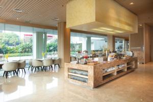 a lobby with a counter and some chairs and windows at Louis Kienne Reserve Cikarang in Cikarang