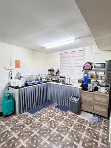 a kitchen with a table and a counter top at Homestay Teera in Chemor
