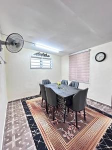 a dining room with a table and chairs at Homestay Teera in Chemor +12 photos
