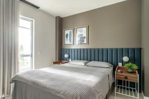 a bedroom with a large bed and a window at Apt Boutique Grande Florianópolis - Sua Estadia SC in São José