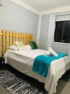 a bedroom with a large bed with a blue blanket at Pousada Portal D'amaro in Santo Amaro