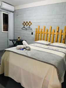 a bed with two stuffed animals on top of it at Pousada Portal D'amaro in Santo Amaro +6 photos