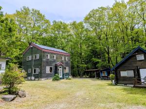 a barn and a house with a yard at のんびれっじひなぎくａ棟 in Anazawa