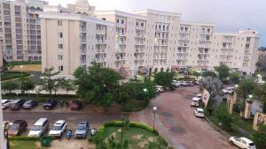 a large building with cars parked in a parking lot at Shubharohi stay in Chhatikara +4 photos