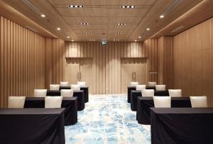 a conference room with rows of tables and white chairs at Louis Kienne Reserve Cikarang in Cikarang +14 photos
