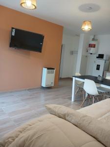 a living room with a table and a tv on the wall at Listo para vos in RSA