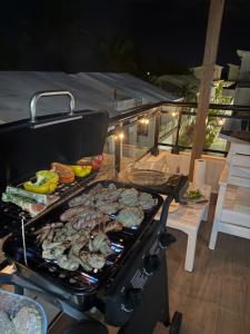 a grill with a lot of food on it at Luxury 3-Bedroom Penthouse, Punta Cana, Pool-BBQ-Beach Access-Private Rooftop-Padel in Punta Cana