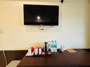 a hotel room table with a tv on a wall at Hotel Ganga Aatitheyam in Haridwār