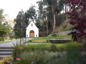 a small white chapel on the side of a road at Casa Betania in La Paz +5 photos