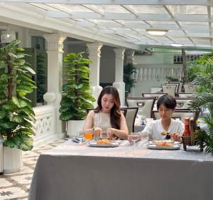 two women sitting at a table eating food at Best House Luang Prabang in Luang Prabang