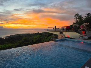 a swimming pool on top of a house with a sunset at Dream View Villa Samal in Samal
