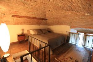 1 dormitorio con cama y pared de ladrillo en Casa Vacanze Piazza Vecchia, en Bérgamo