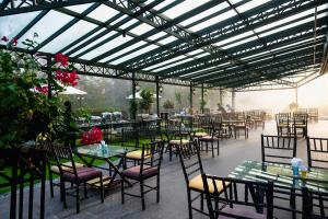 a restaurant with tables and chairs and a glass ceiling at Binh An Village Resort in Da Lat