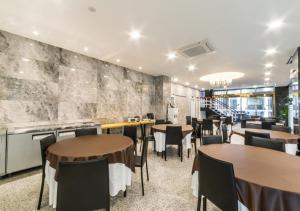 a restaurant with tables and chairs in a room at Gimpo Pentastar Hotel in Gimpo