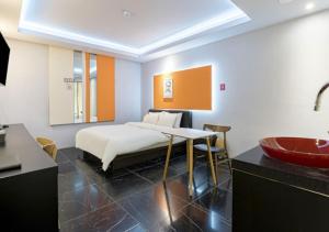 a bedroom with a bed and a sink and a tub at Gimpo Pentastar Hotel in Gimpo
