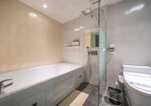 a bathroom with a tub and a sink and a shower at Gimpo Pentastar Hotel in Gimpo +21 photos