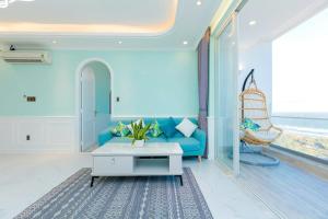 a living room with a blue couch and a table at Căn Hộ View Biển Santorini, Vũng Tàu in Vung Tau