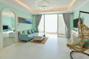 a living room with a blue couch and a chair at Căn Hộ View Biển Santorini, Vũng Tàu in Vung Tau