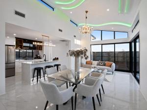 a dining room and kitchen with a glass table and chairs at The Gem - 5 bedroom brand new house in Christchurch