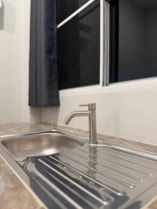 a stainless steel sink in a kitchen with a window at ภูไทโฮมสเตย์ บ้านกุดหว้า in Ban Don Um Lua +16 photos