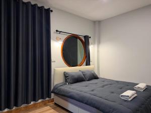 a bedroom with a bed and a mirror at ภูไทโฮมสเตย์ บ้านกุดหว้า in Ban Don Um Lua