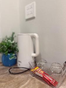 a counter top with a coffee maker and two glasses at ภูไทโฮมสเตย์ บ้านกุดหว้า in Ban Don Um Lua